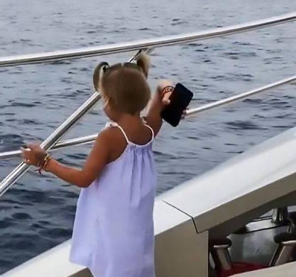 لقطات طريفة لطفلة ترمي هاتف والدها في البحر (فيديو)