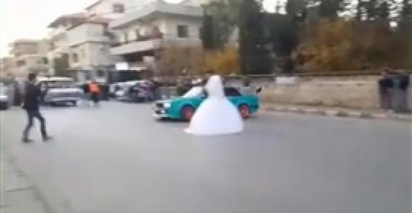 بالفيديو.. عروسان يغامران بحياتهما أمام سيارة