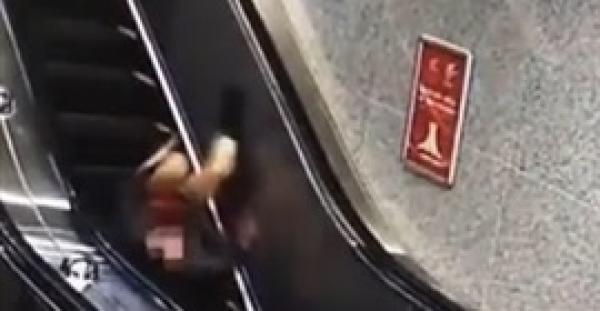 بالفيديو.. لحظة سقوط فتاة حسناء من أعلى سلم كهربائي بسبب كعبها العالي