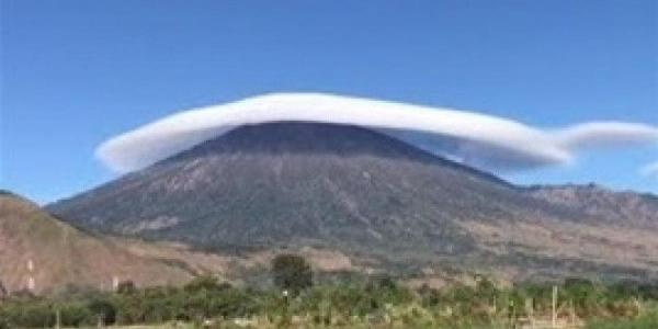 طبقات كثيفة من الغيوم تشكل قبعة فوق بركان في مشهد مذهل