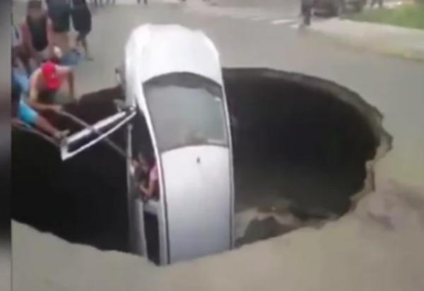 بالفيديو: حفرة ضخمة تبتلع سيارة بمن فيها