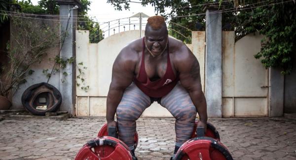 أقوى رجل في أفريقيا يتناول 8 دجاجات يوميا ويرفع 220 كغ(فيديو)