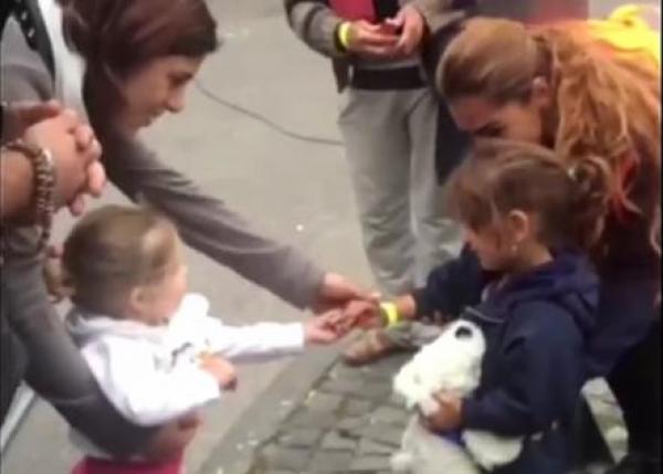 بالفيديو: لحظة مؤثرة لطفلة ألمانية تقدم الحلوى لطفلة سورية لاجئة