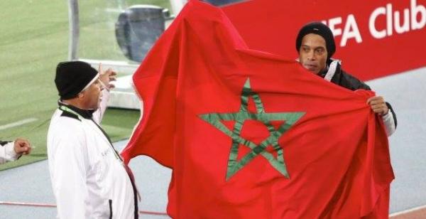 بالصور: رونالدينيو يحمل العلم الوطني ويطوف به على جنبات الملعب