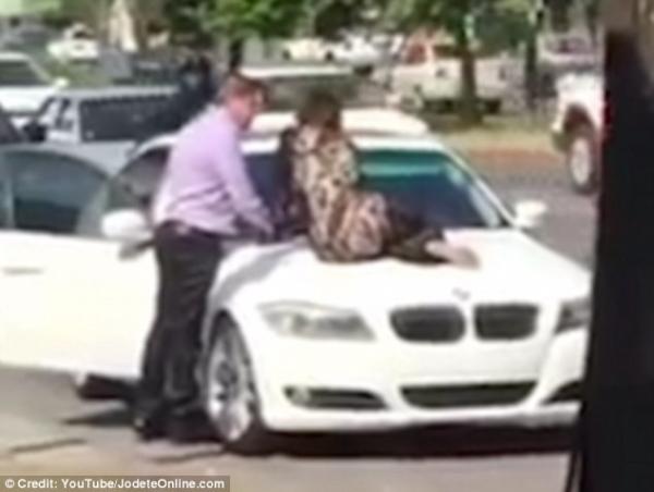 بالفيديو .. مكسيكية تجلس علي سيارة زوجها لمنعه من الخروج