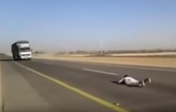 بالفيديو: شاب يستعرض بالارتماء أمام شاحنة مسرعة