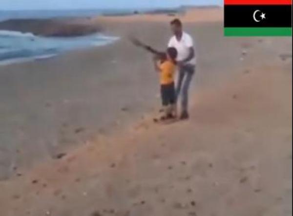بالفيديو ...رجلين يعلمان طفلا ليبيا على استخدام الـ "آر بي جي"